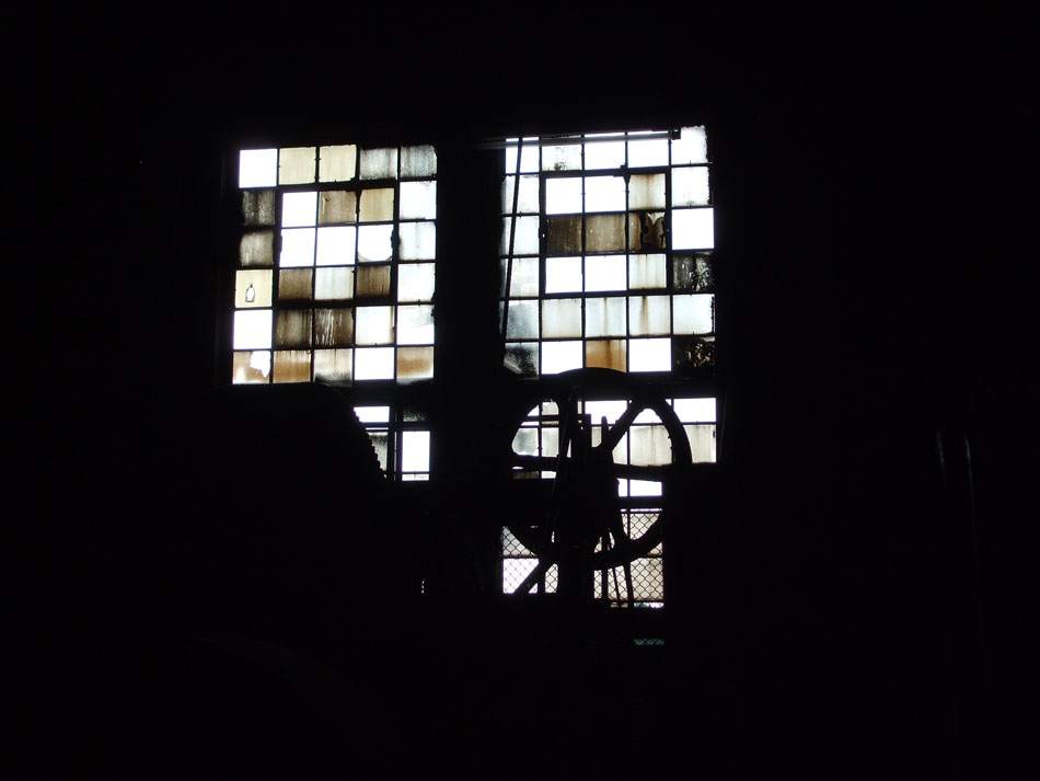 Leuchtendes Sprossenfenster in dunkler Industriehalle