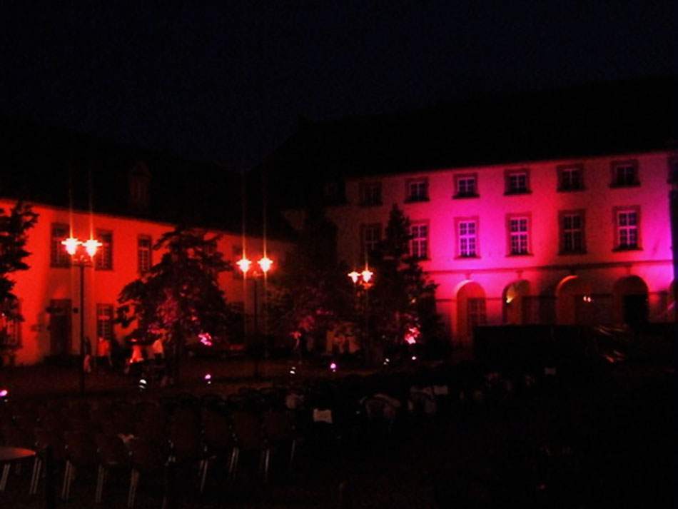 Historisches Gebäude bei Nacht in Rot und Magenta illuminiert